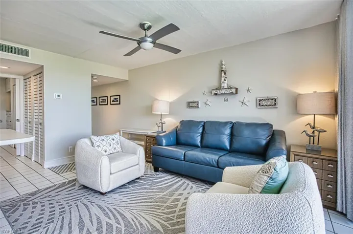Living room with tile patterned flooring and a ceiling fan