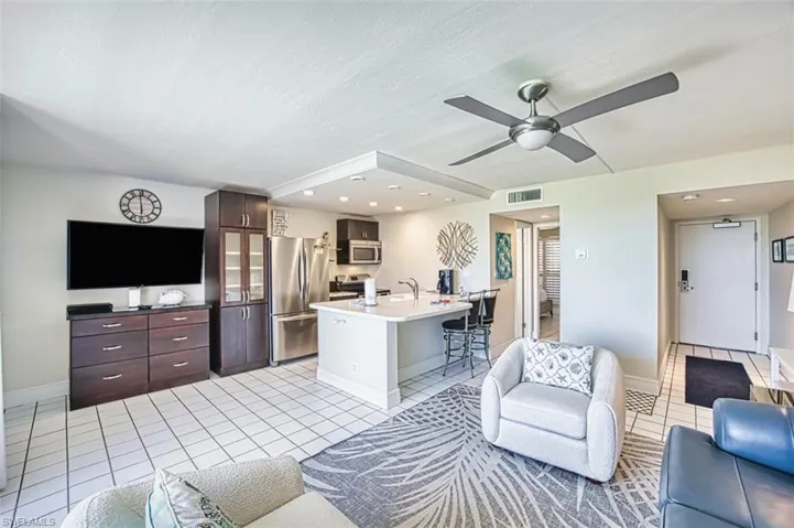 Living room featuring light tile patterned flooring, recessed lighting, ceiling fan, and a textured ceiling