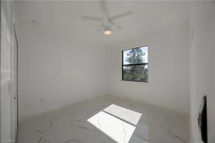 2nd bedroom with light marble finish flooring and ceiling fan