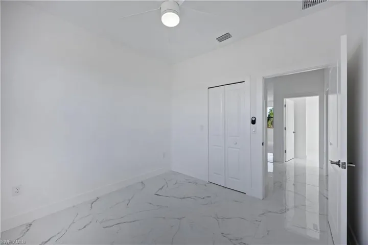 Spare room featuring light marble tile finish flooring and baseboards