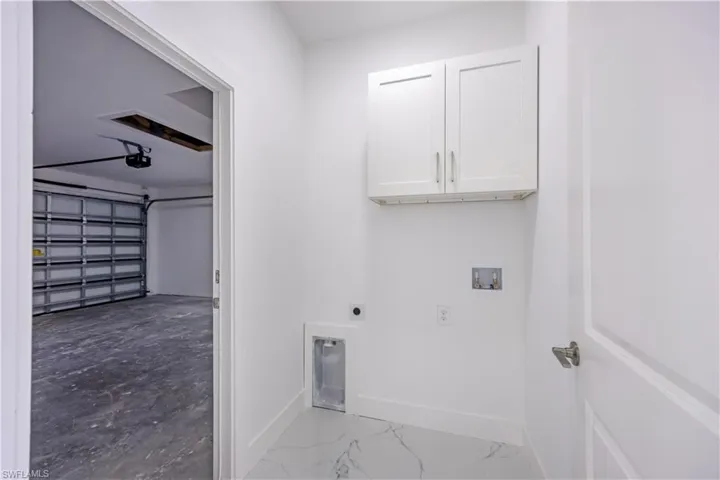 Laundry room with a garage, electric dryer hookup, cabinet space, and hookup for a washing machine