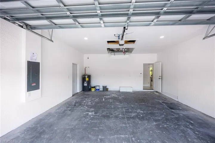 Garage featuring electric panel and water heater