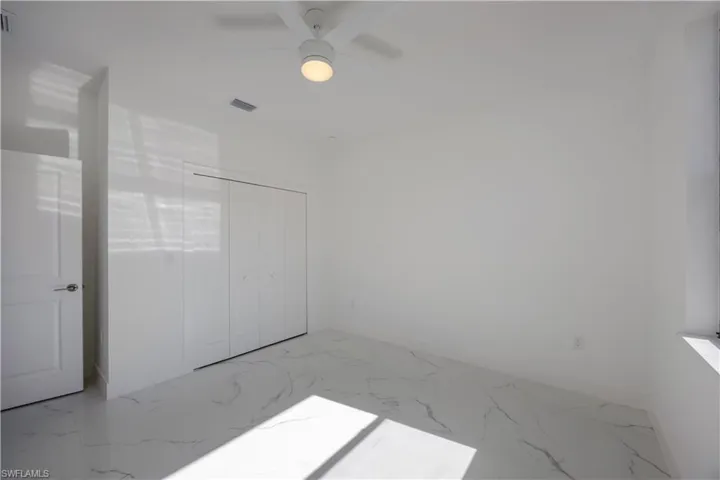 2nd bedroom with a closet, a ceiling fan, and marble finish flooring