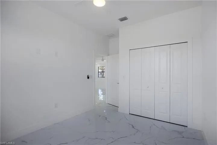 3rd bedroom featuring a closet, marble finish floors, and a ceiling fan