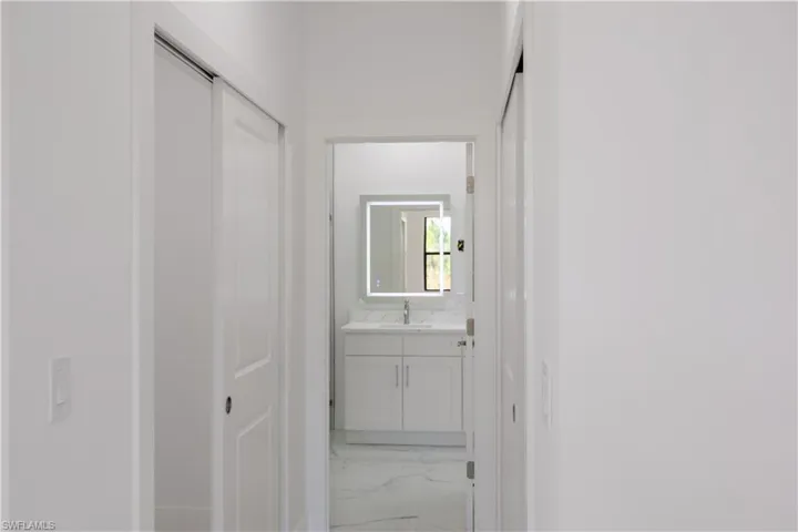 Hall with light marble finish floors and a sink