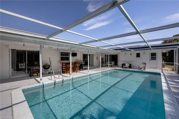 Outdoor pool with a lanai, a sunroom, and a patio area