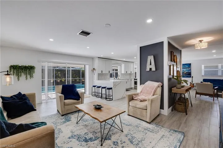 Living room with light wood-style flooring and recessed lighting