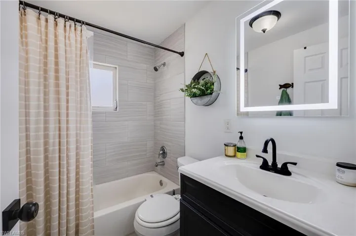 Bathroom with shower / tub combo and vanity