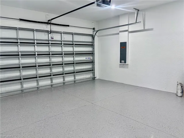 Garage featuring electric panel and a garage door opener