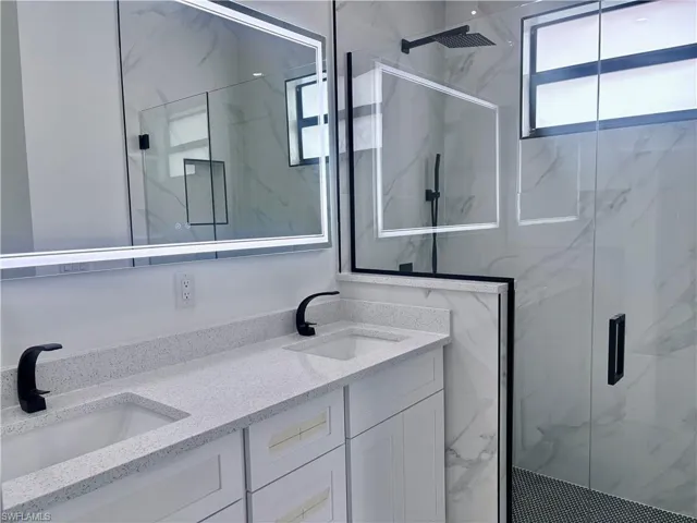Bathroom featuring vanity and an enclosed shower