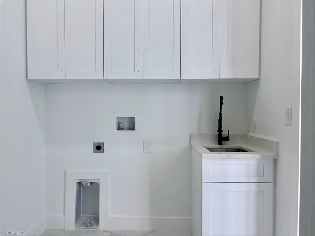 Laundry area featuring electric dryer hookup, cabinets, sink, and hookup for a washing machine