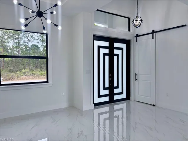 Foyer entrance with a barn door and an inviting chandelier