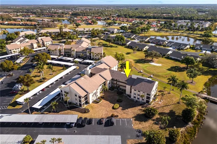 Aerial view of property and surrounding area with a large body of water and a golf course