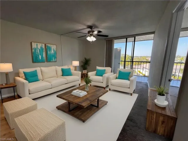Living room featuring expansive windows, baseboards, wood finished floors, and ceiling fan