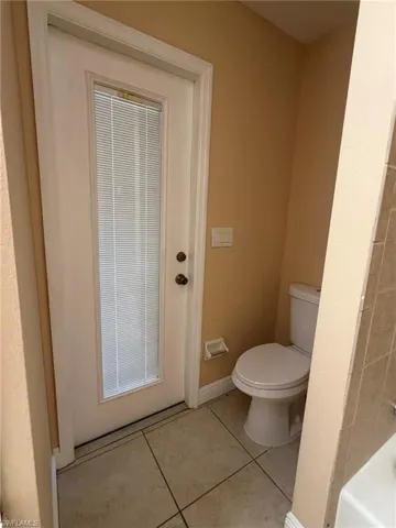 Full bath with light tile patterned floors and a bathtub