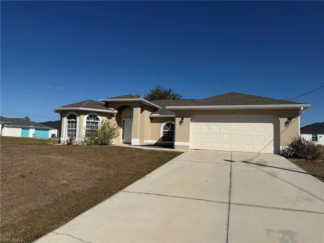View of front of house featuring stucco siding, driveway, an attached garage, a front lawn, and a shingled roof