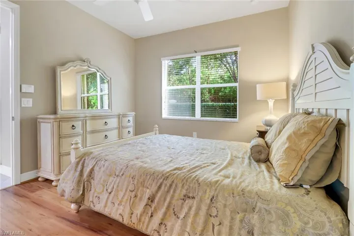 Bedroom featuring multiple windows, light wood-style flooring, and a ceiling fan