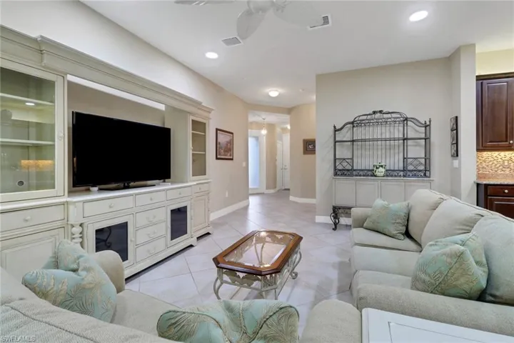 Living area featuring ceiling fan, light tile patterned flooring, and recessed lighting