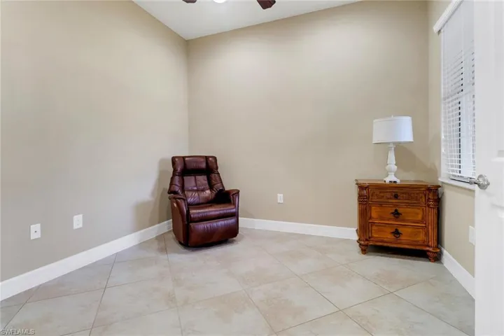 Living area featuring a ceiling fan and light tile patterned floors