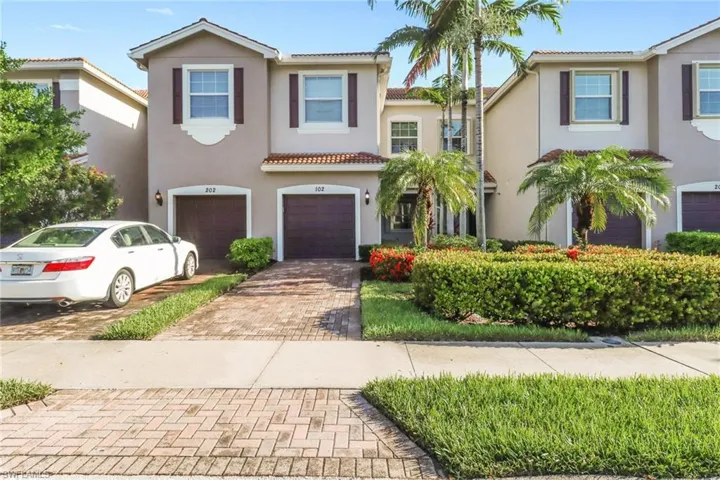 Mediterranean / spanish-style house with decorative driveway, an attached garage, stucco siding, and a tile roof