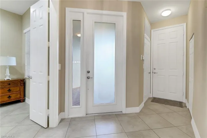 Foyer with baseboards and light tile patterned floors
