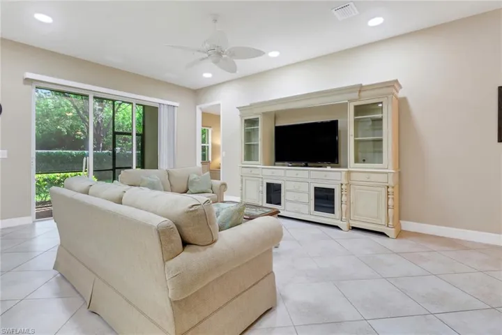 Living area with a ceiling fan, light tile patterned floors, and recessed lighting