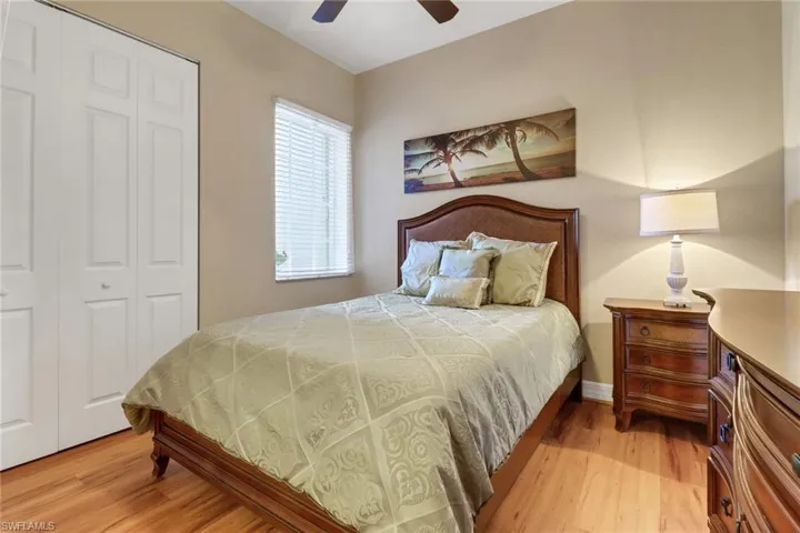 Bedroom with light wood finished floors, a closet, and ceiling fan