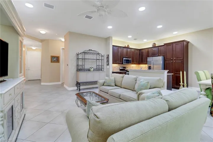 Living area featuring a ceiling fan, light tile patterned floors, and recessed lighting