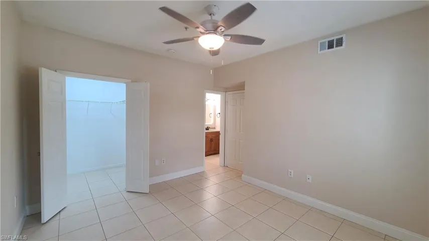 View of bedroom with open walk-in closet doors.