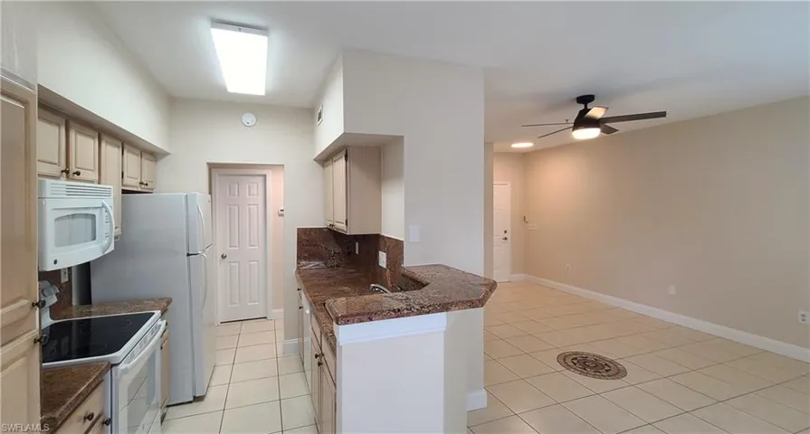 View from dining area with kitchen and living room areas.