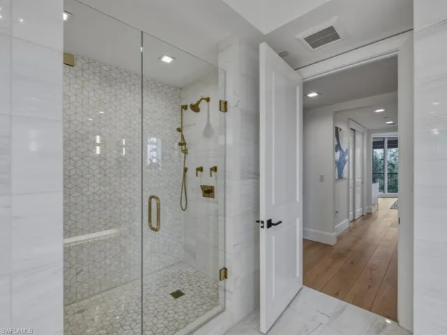 Bathroom with marble surround, light flooring, and recessed lighting