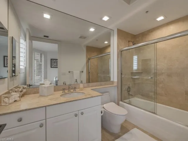 Full bath with vanity and bath / shower combo with glass door