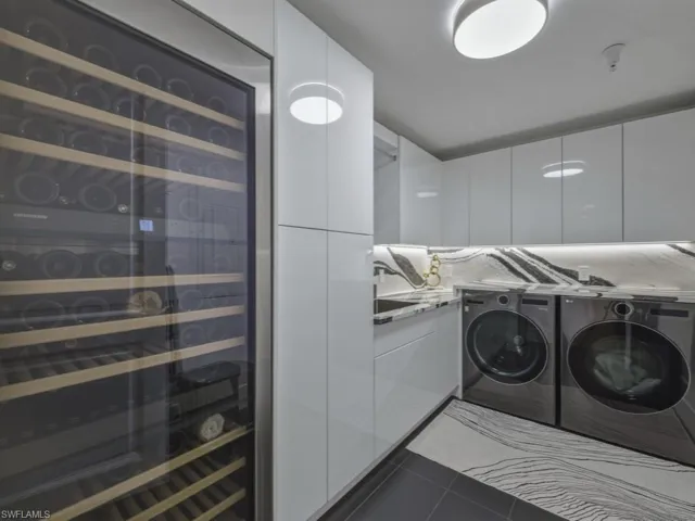 Laundry area with wine refrigerator, quartz counters, and separate washer and dryer