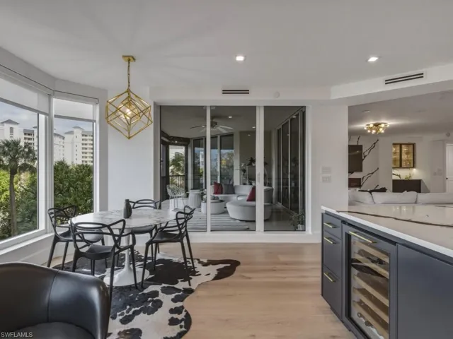 Dining room featuring Miele wine cooler, light wood-type flooring, suspended lighting, and ceiling fan