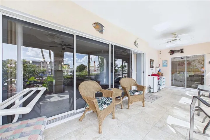 Sunroom with a ceiling fan and a patio