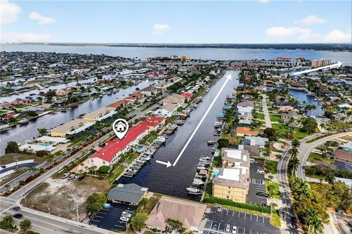 Aerial view of property's location with a large body of water and nearby suburban area