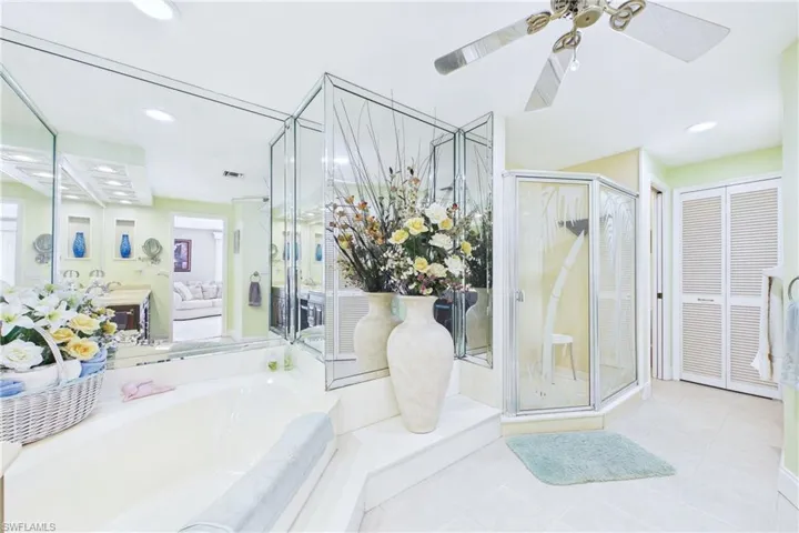 Ensuite bathroom with a garden tub, a ceiling fan, a stall shower, recessed lighting, and a closet
