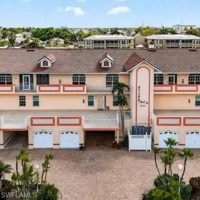 View of front of property with a garage, driveway, stucco siding, and a balcony