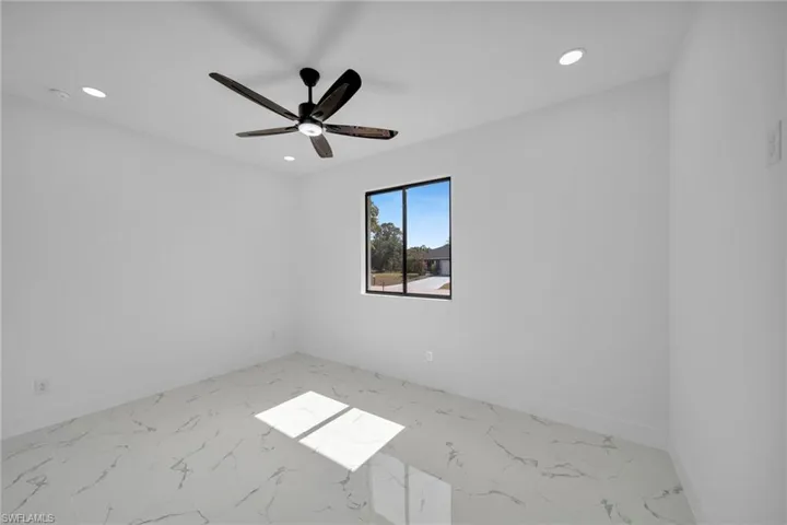 Empty room featuring light marble finish flooring, recessed lighting, and ceiling fan