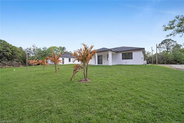 View of front of home with a front yard and stucco siding