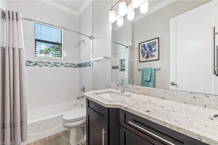 Full bathroom featuring crown molding, vanity, shower / tub combo with curtain, and wood finished floors
