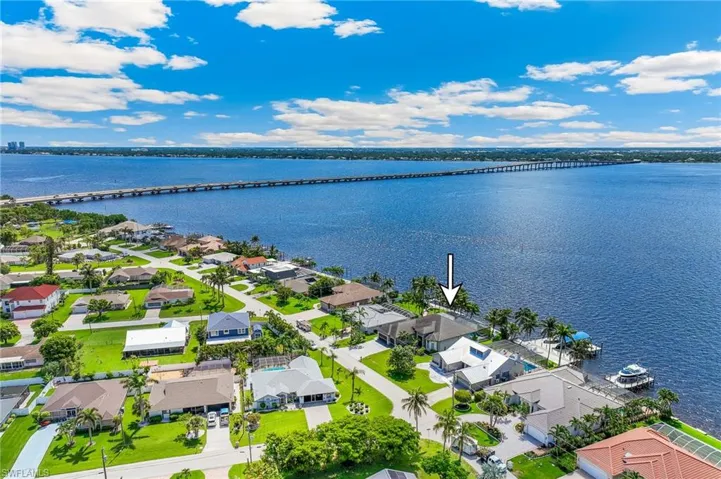 Aerial perspective of suburban area with a notable bridge and a nearby body of water