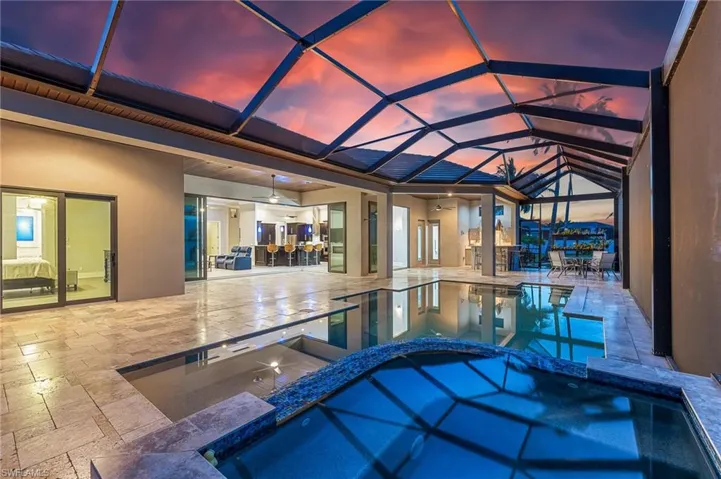 View of swimming pool with a pool with connected hot tub, a ceiling fan, a patio area, a lanai, and area for grilling