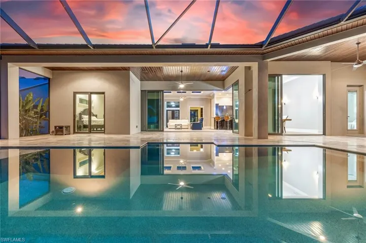 View of pool with a ceiling fan, a swimming pool, a patio, and a lanai