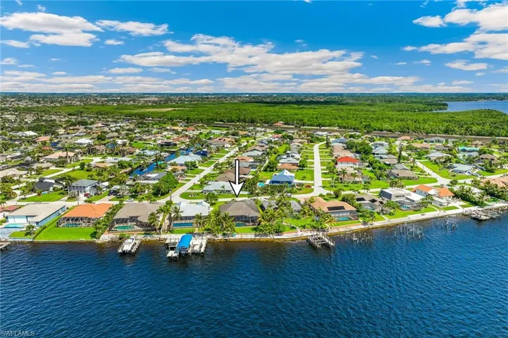 Aerial view of residential area featuring a nearby body of water