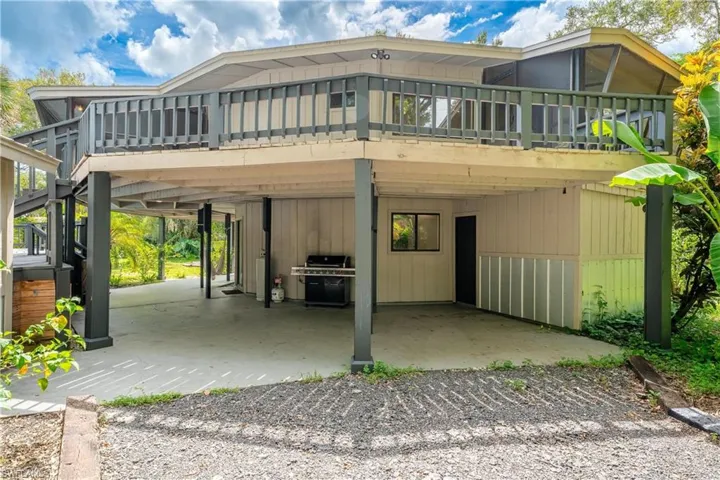 Rear view of house featuring a patio area and a wooden deck