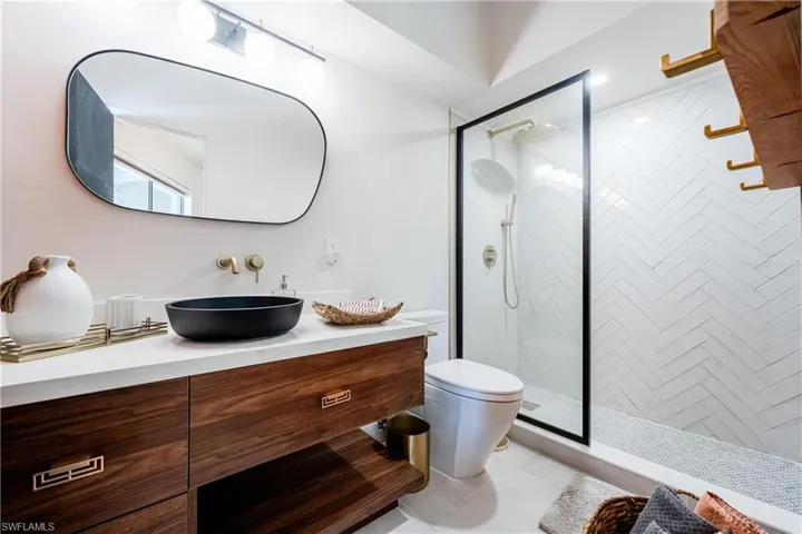 Bathroom featuring vanity, toilet, a shower with shower door, and tile patterned flooring