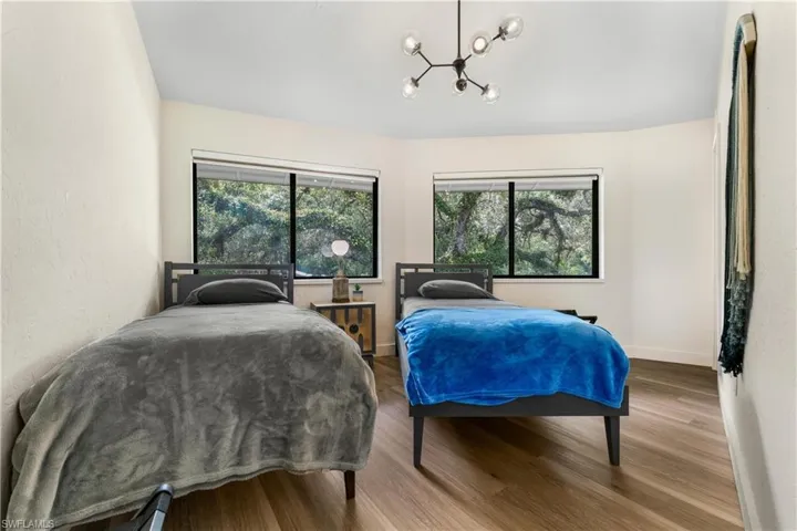 Bedroom with wood-type flooring and a notable chandelier