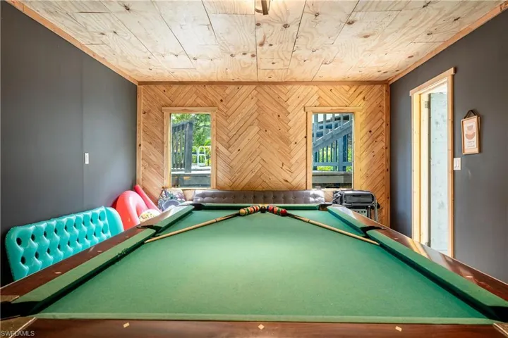 Game room with wood walls, pool table, and wood ceiling