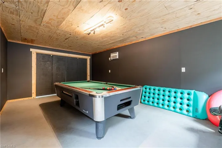 Rec room featuring billiards, concrete floors, wooden ceiling, and a wall mounted air conditioner